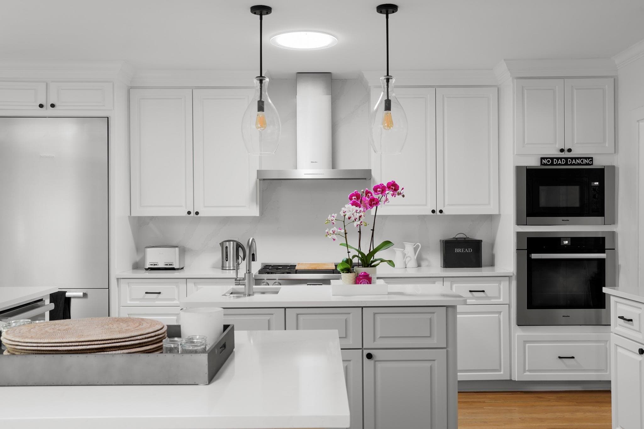 Kitchen with built in appliances, white cabinetry
