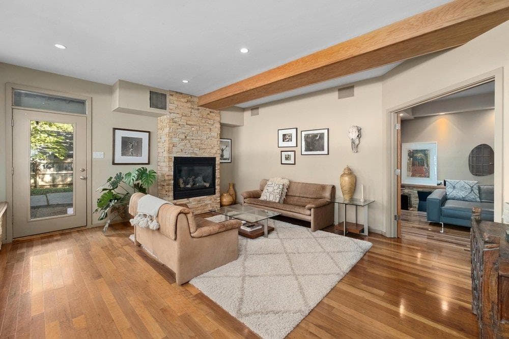 Living area with a stone fireplace, hardwood / wo