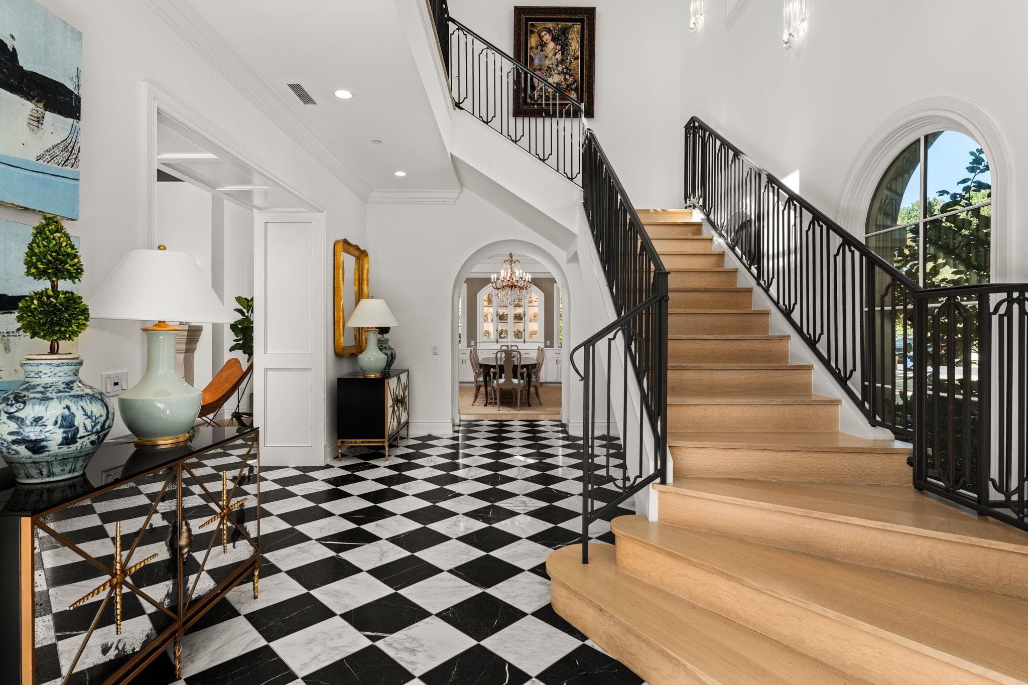 An elegant staircase rises alongside classic chec