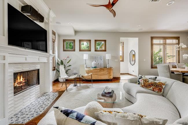 Living room with a ceiling fan, a tiled fireplace